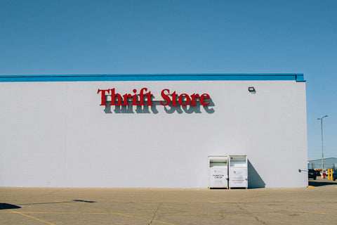 White building with 'Thrift Store' sign on a clear blue sky background