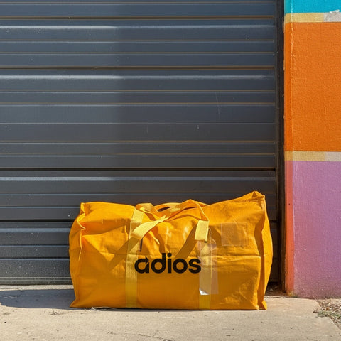 Yellow Adios Austin goodbye bag leaning against colorful wall - say adios and declutter your stuff in Austin Texas for donation pickup and reuse